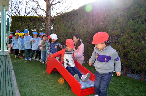 園庭のすべり台で遊ぶ子どもたち